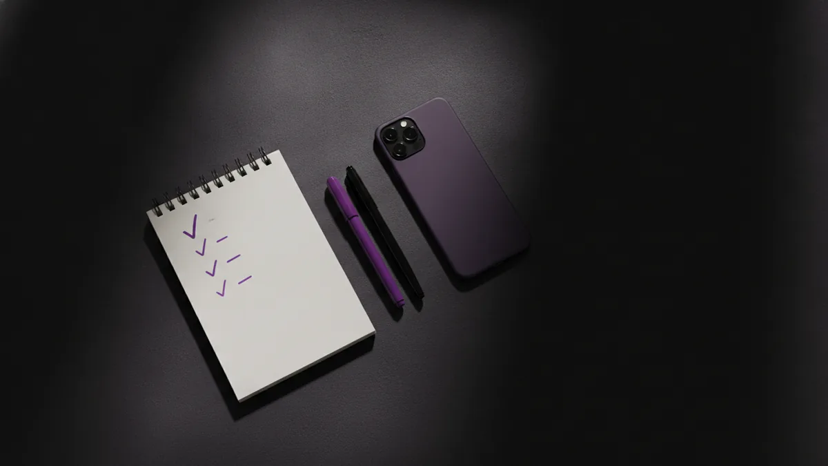 Smartphone next to a checklist notebook with pen and highlighter for optimization.