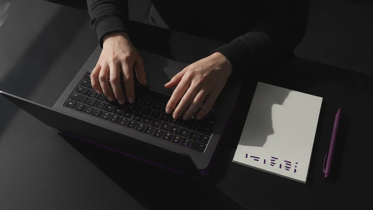 Typing on a laptop with short notes to plan a readable Instagram bio