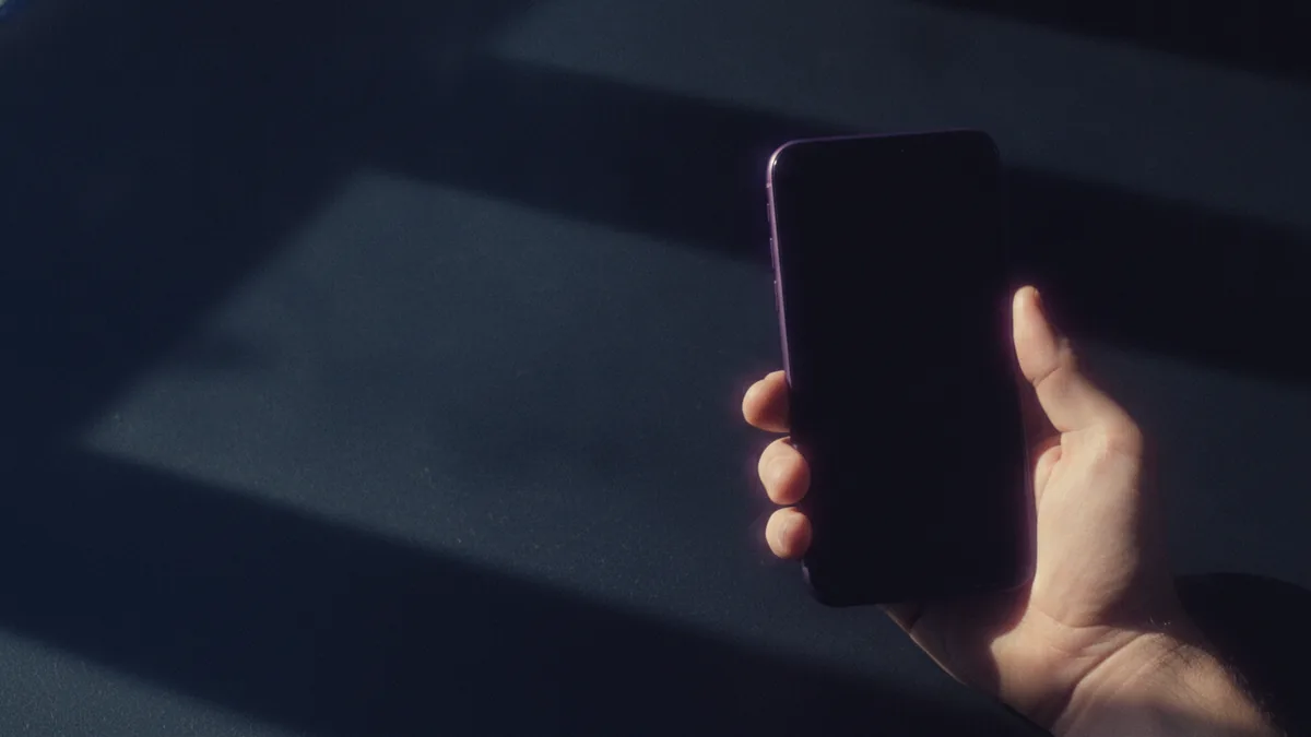 Hand holding a smartphone as if updating an Instagram profile
