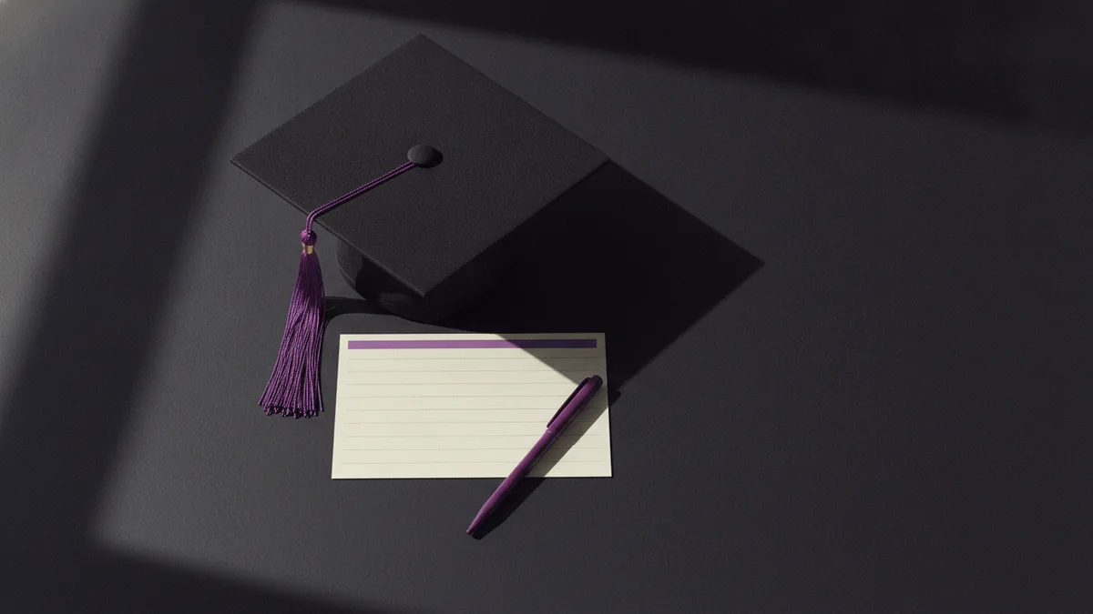Graduation cap and writing tools showing what to include in a degree bio