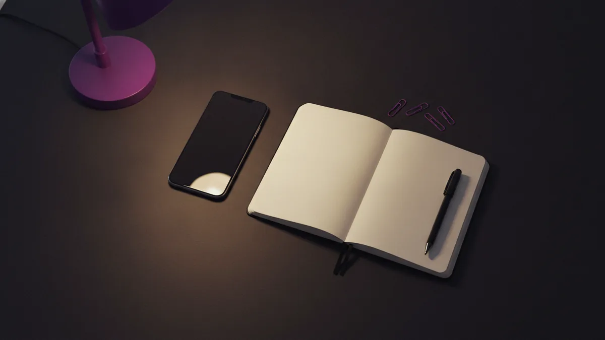 Drafting your bio Notebook and phone on a desk for drafting a short Instagram bio.
